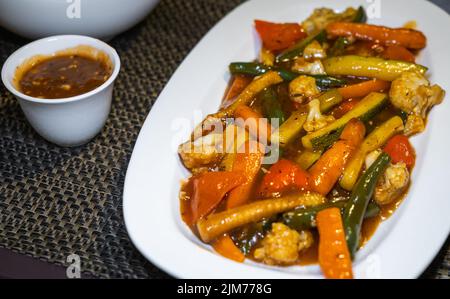 Légumes sautés composés de courgettes, maïs pour bébés, brocolis, haricots, carottes, Champignons, chou-fleur et poivrons dans une sauce au poivre noir. Banque D'Images