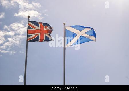 Les drapeaux écossais et britanniques agitant dans le vent Banque D'Images