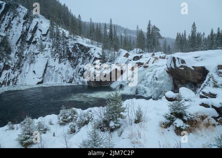 Cascade de Hyttfossen sur la rivière Gaula en hiver. Paysage enneigé du centre de la Norvège. Site touristique sur le chemin de Roros. Banque D'Images