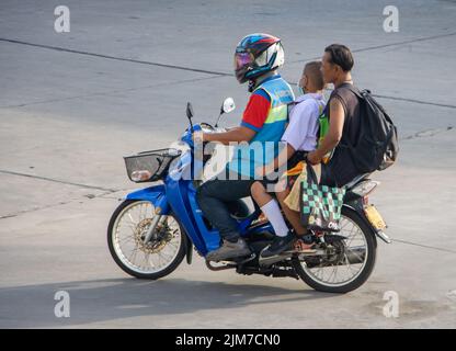 SAMUT PRAKAN, THAÏLANDE, MAI 30 2022, Un moto taxi transporte un homme et un garçon dans un uniforme scolaire Banque D'Images