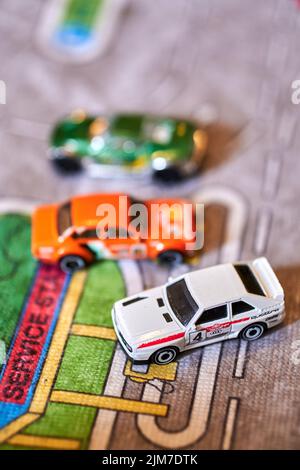 Vue verticale en haut des modèles réduits de voitures Mattel Hot Wheels, dont Audi Quattro sur une piste de jeu Banque D'Images