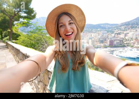 Une jeune fille touristique attirante prend une photo de selfie avec le paysage urbain de Monte-Carlo, Monaco Banque D'Images