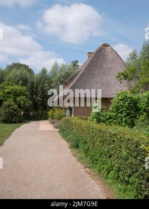 Route poussiéreuse vers une ancienne maison avec un grand toit de chaume de la province de Flandre Occidentale en Belgique située à Bokrijk Banque D'Images