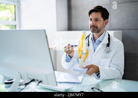 Orthopédiste médecin médecin montrant l'articulation squelettique dans la vidéoconférence médicale Banque D'Images