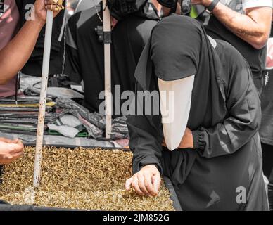 Une femme musulmane inconnue portant le nikab ou la burka choisit l'un des nombreux anneaux d'or pour un doigt sur un souq en algérie. Banque D'Images