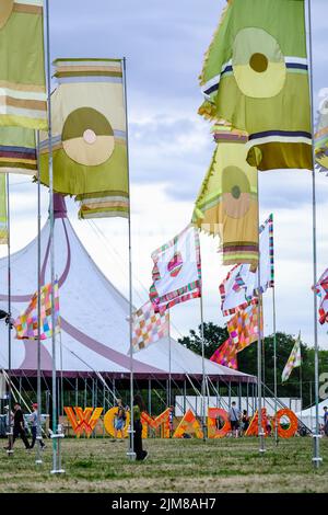 Les drapeaux survolent le panneau WOMAD 40 tandis que le festival célèbre ses 40th ans photographiés pendant le WOMAD 40th (World of Music Arts and Dance) qui s'est tenu à Charrlton Park , Malmesbury le jeudi 28 juillet 2022 . Photo de Julie Edwards. Banque D'Images