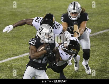 Canton, États-Unis. 04th août 2022. Les Raiders de Las Vegas Ameer Abdullah (22) est repris par les jaguars Shaquille Quarterman (50) et Andrew Wingard (42) lors d'une course dans la première moitié du Pro football Hall of Game à Canton, Ohio, jeudi, 4 août 2022. Photo par Aaron Josefczyk/UPI crédit: UPI/Alay Live News Banque D'Images