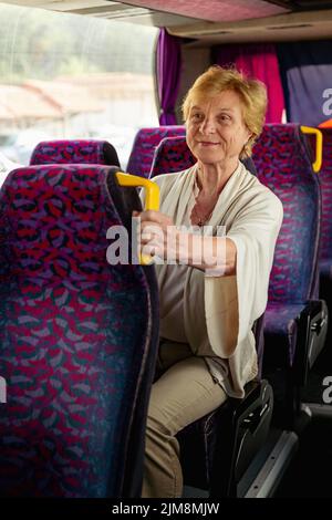 Femme âgée assise dans un bus de voyage et attendant l'excursion Banque D'Images