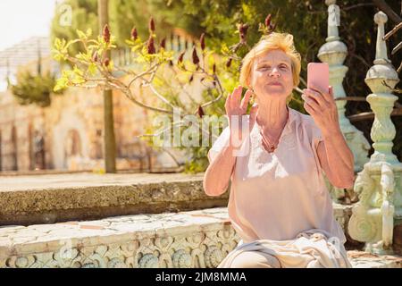 Femme adulte voyageur assis sur des marches et utilisant un téléphone portable Banque D'Images