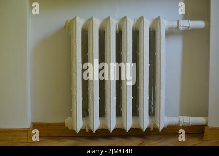 Des tuyaux et un radiateur de chauffage blanc chauffent la pièce. saison de chauffage Banque D'Images