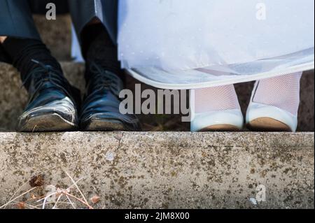 Mariée et marié dans des chaussures de mariage utilisées. Couple de repos Banque D'Images