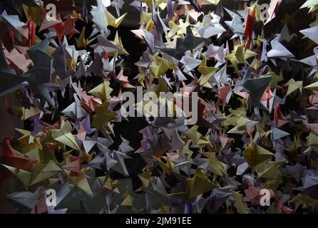 Grues artisanales en papier colorées faites à la main sur cordes Banque D'Images