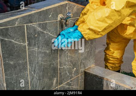 Image d'un gant de protection lors du lavage à la fontaine, prise de vue du côté opposé avec mise au point sélective. Banque D'Images