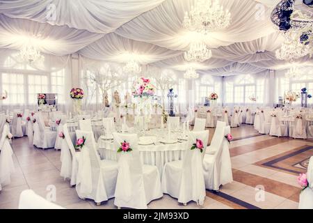 Avant le banquet de mariage. Une grande salle dans le restaurant, préparée pour un dîner de mariage. Banque D'Images