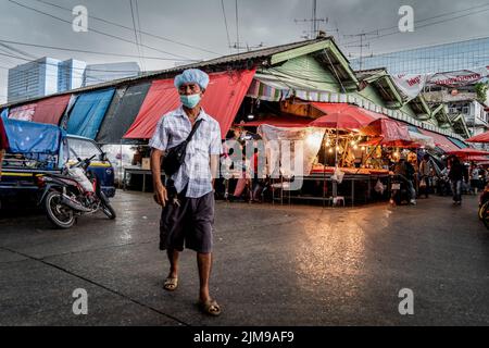 Bangkok, Thaïlande. 05th août 2022. Un client mystère traverse des inondations lors de fortes pluies au marché humide de Khlong Toey à Bangkok. La vie quotidienne autour du marché de Khlong Toey Wet à Bangkok. Alors que le tourisme continue de croître avec l'arrivée de 3 millions de touristes internationaux cette année, le taux d'inflation de détail de la Thaïlande a augmenté de 7,66% depuis un an, ce qui l'a porté à un niveau élevé de 14 ans et a conduit à des spéculations selon lesquelles la banque centrale augmentera le taux d'intérêt en août 2022. Crédit : SOPA Images Limited/Alamy Live News Banque D'Images