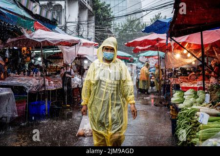 Bangkok, Thaïlande. 05th août 2022. Un client mystère traverse des inondations lors de fortes pluies au marché humide de Khlong Toey à Bangkok. La vie quotidienne autour du marché de Khlong Toey Wet à Bangkok. Alors que le tourisme continue de croître avec l'arrivée de 3 millions de touristes internationaux cette année, le taux d'inflation de détail de la Thaïlande a augmenté de 7,66% depuis un an, ce qui l'a porté à un niveau élevé de 14 ans et a conduit à des spéculations selon lesquelles la banque centrale augmentera le taux d'intérêt en août 2022. Crédit : SOPA Images Limited/Alamy Live News Banque D'Images