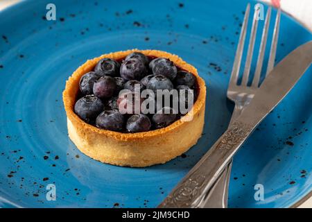Tarte aux myrtilles fraîchement cuite sur une assiette en porcelaine bleue Banque D'Images