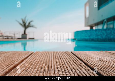 Terrasse en bois vide avec piscine, belle vue minimaliste sur la piscine avec ciel bleu clair. La couleur du filtre vintage s'applique . Banque D'Images