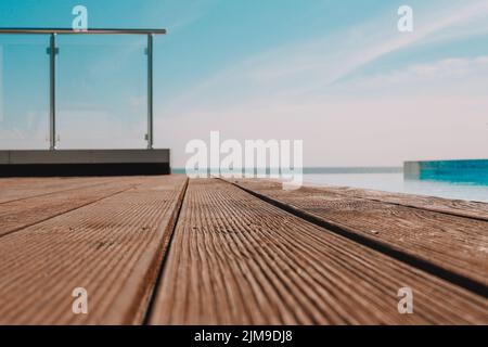 Terrasse en bois vide avec piscine, belle vue minimaliste sur la piscine avec ciel bleu clair. La couleur du filtre vintage s'applique . Banque D'Images