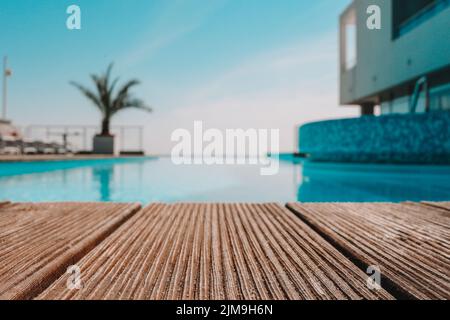 Terrasse en bois vide avec piscine, belle vue minimaliste sur la piscine avec ciel bleu clair. La couleur du filtre vintage s'applique . Banque D'Images