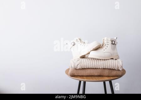 Pile de chandails et de bottes sur une table en bois. Placer pour le texte. Publicité. Banque D'Images