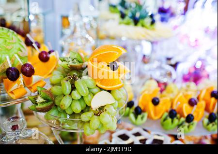 Table de réception de mariage élégance avec de la nourriture et le décor. Raisin blanc, orange et autres fruits Banque D'Images