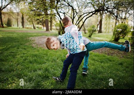 Deux frère garçon avec des écouteurs s'amusant sur parc. Frère de l'amour. Banque D'Images