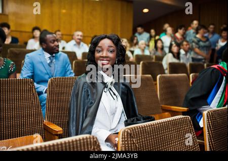 Happy black african american girl with hat and gown finissants au diplôme cérémonie Banque D'Images