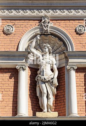 Statue de femme à la torche sur un vieux mur décoré Banque D'Images