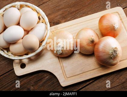 Nature morte avec oignons et oeufs de caille sur une table de cuisine Banque D'Images