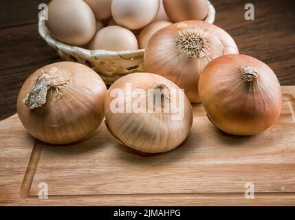 Nature morte avec oignons et oeufs de caille sur une table de cuisine Banque D'Images