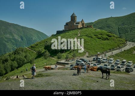 Stepantsminda, Géorgie montrant l'église de la Trinité de Gergeti, Tsminda Sameba ou l'église de la Sainte Trinité, près du village de Gergeti vue extérieure en plein jour. Banque D'Images