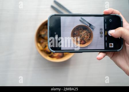 Shoot First Eat later concept, le tournage thaï épice herbe pâtes vue. Médias sociaux, partage de repas. Banque D'Images