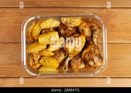 Cuisses de poulet rôties et pommes de terre cuites sur une table en bois. Vue de dessus. Banque D'Images