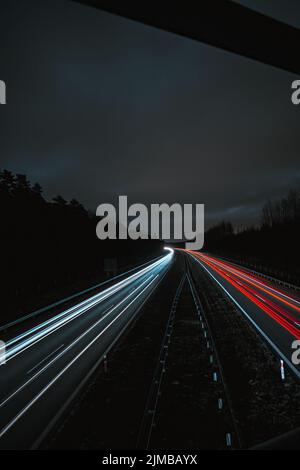 Une vue sur les sentiers de lumière sur la route pendant une nuit sombre Banque D'Images