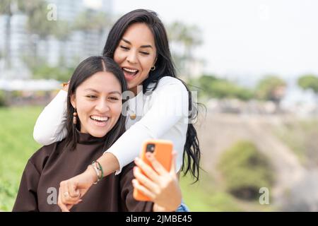 Portrait de deux femmes qui s'amusent tout en prenant un selfie à l'extérieur Banque D'Images