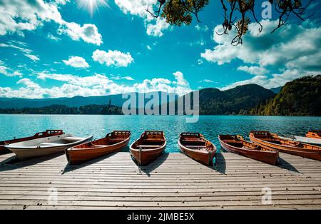 Bateaux en bois traditionnels Pletna les sur le backgorund de Église de l'île sur le lac de Bled, en Slovénie. L'Europe. Banque D'Images