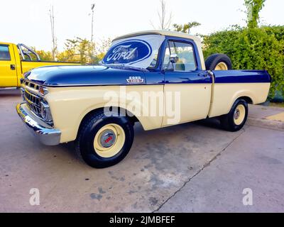 Logo ovale bleu Ford et marque sur le pare-brise d'un ancien pick-up utilitaire F100 V8 1963. Vue latérale. Expo Fierro 2022 salon de voiture classique Banque D'Images