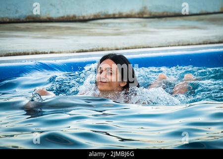 Femme caucasienne nageant avec un dauphin dans la piscine. Batumi nage avec le concept de l'expérience dauphin Banque D'Images