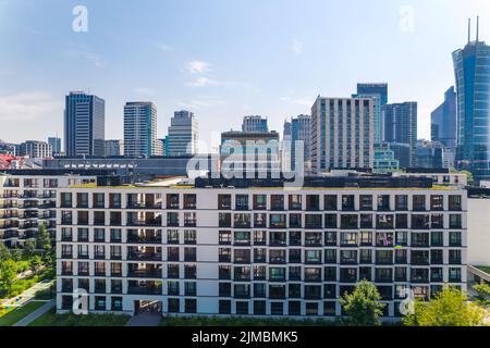 7.22.2022 Varsovie, Pologne. Fenêtres et balcons d'appartements de plusieurs étages au premier plan, gratte-ciel en arrière-plan. Ciel bleu clair. Photo de haute qualité Banque D'Images