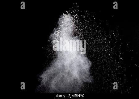 Explosion de poudre blanche isolé sur fond noir. Les particules de poussière blanc splash. Banque D'Images