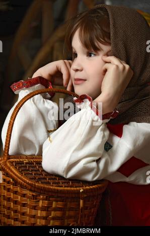 Belle jeune fille en costume russe assis dans un intérieur traditionnel Banque D'Images