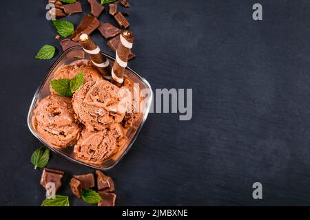 Ramasse la glace au chocolat dans un bol en verre Banque D'Images