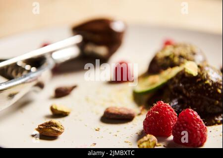 Concentrez-vous sur les framboises mûres sur une assiette blanche avec de la glace au chocolat Banque D'Images