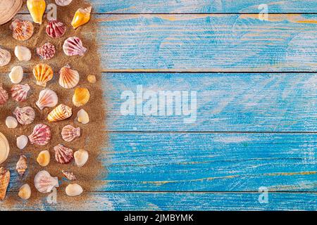 Concept de l'heure d'été avec coquillages sur fond de bois bleu et sable Banque D'Images