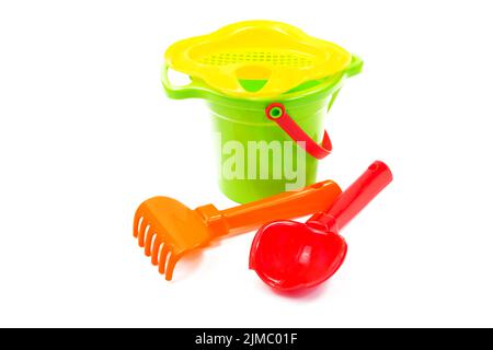 Les jouets pour enfants pelle godet et du râteau isolé sur le livre blanc Banque D'Images