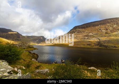 Lac ou llyn Ogwen avec plume de montagne an ole wen derrière. Avec le Nant Ffranson Pass, Bethesda, Snowdonia, pays de Galles du Nord, Royaume-Uni, Banque D'Images