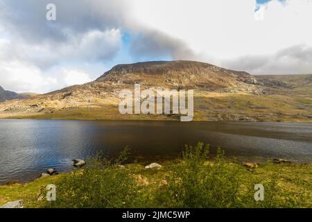 Lac ou llyn Ogwen avec plume de montagne an ole wen derrière. Avec le Nant Ffranson Pass, Bethesda, Snowdonia, pays de Galles du Nord, Royaume-Uni, grand angle Banque D'Images