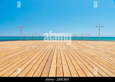 Plate-forme en bois clair sur la côte de la mer lors d'une journée d'été sur la côte de Chypre. Banque D'Images