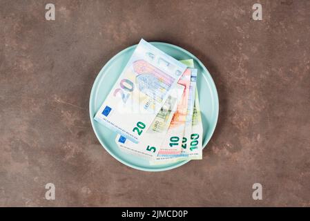 Plaque avec des billets en euros, pénurie alimentaire et augmentation des prix, pauvreté par l'inflation Banque D'Images